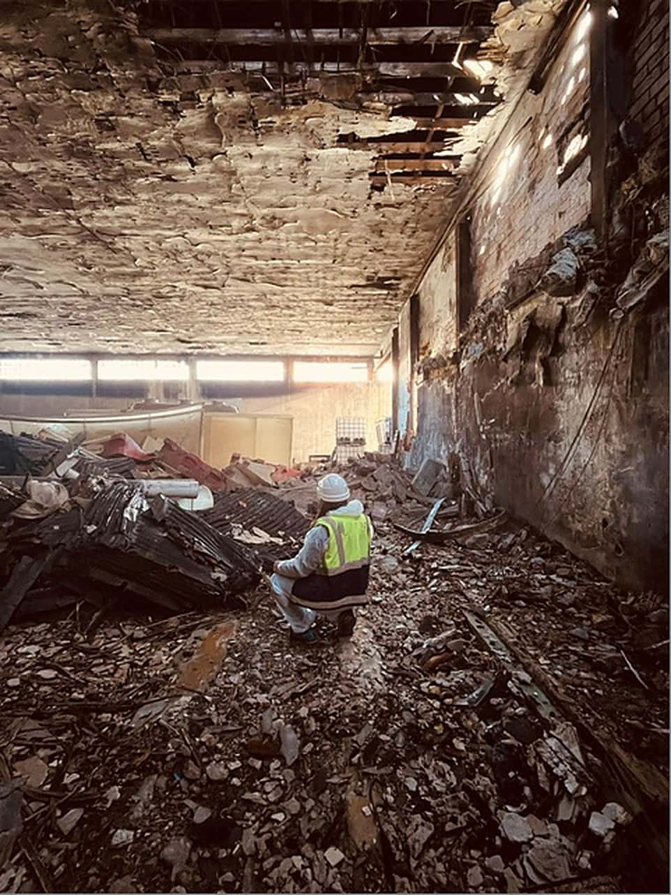 Técnica de CORT inspeccionando el interior de una nave industrial en demolición
